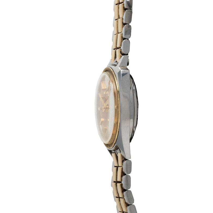 Two-tone Bulova Accutron watch with oval face, gold bezel, and linked metal bracelet shown from side profile.