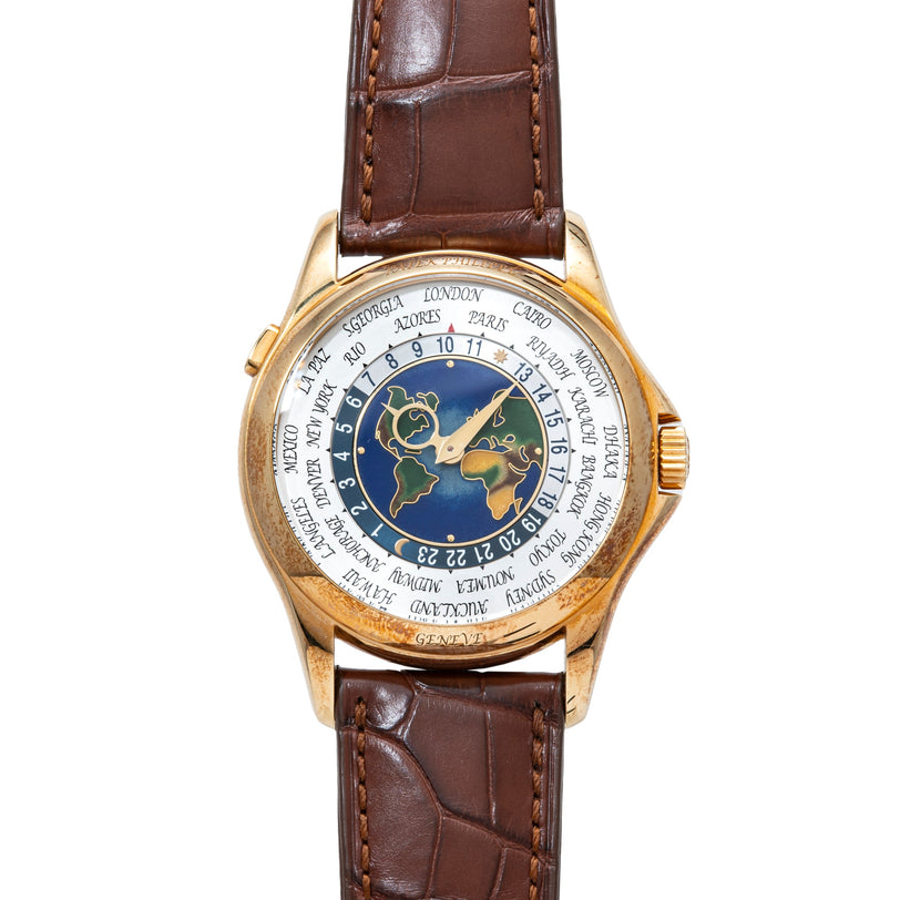 Gold-tone watch with world map cloisonné dial, city names around edge, and brown crocodile leather strap.