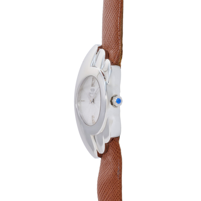 White oval watch with blue crown and brown textured leather strap.