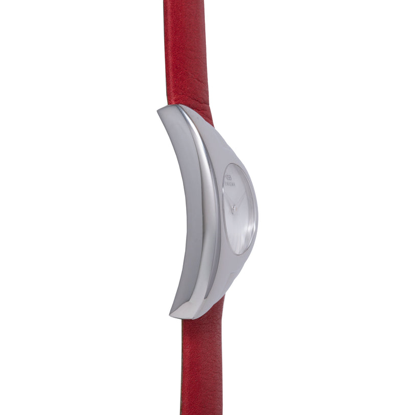 Silver curved watch case with white dial on red fabric strap.