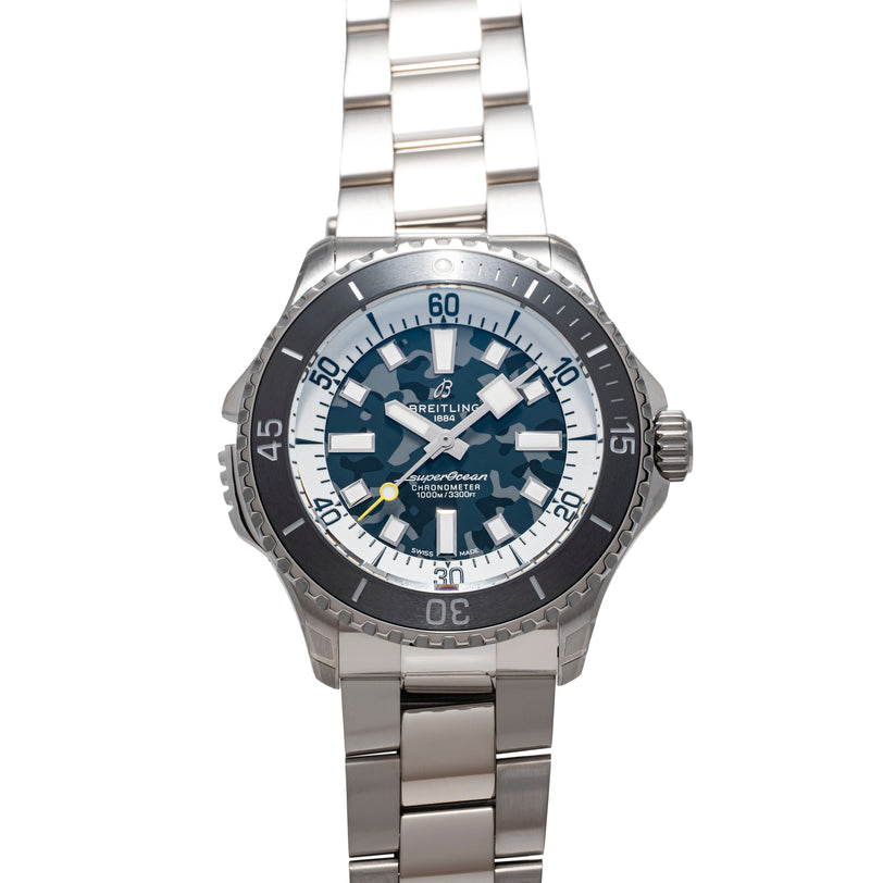 Stainless steel watch with dark bezel, white and blue dial, hour markers, and matching metal bracelet.