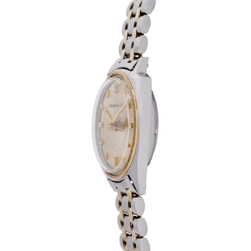 Bulova Accutron watch with oval cream dial, two-tone metal case, and linked bracelet with alternating silver and gold-tone se