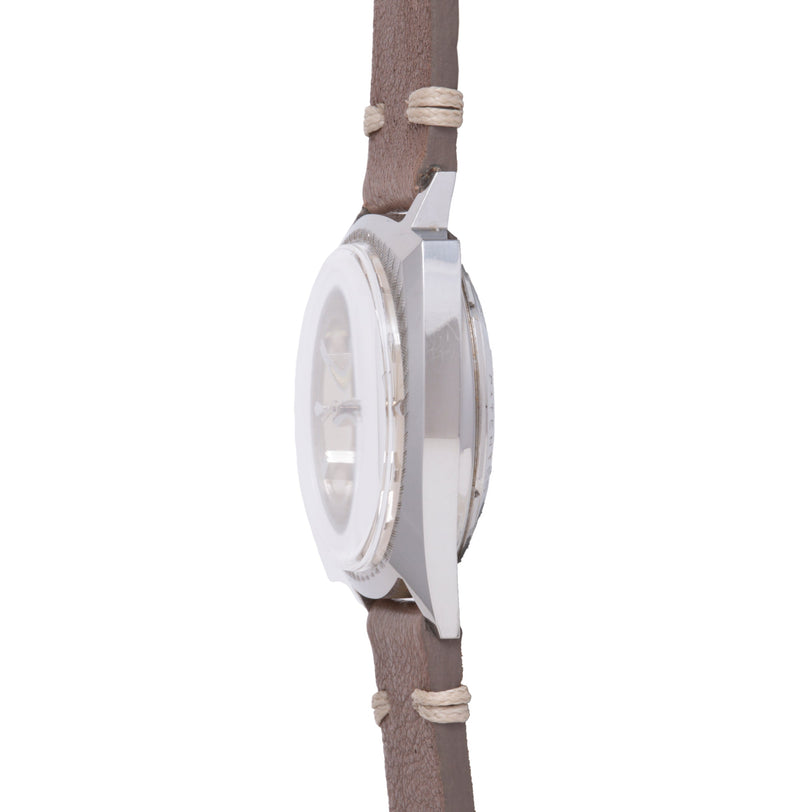 White Bulova Accutron watch with oval case on tan fabric strap with beige cord wrapping.