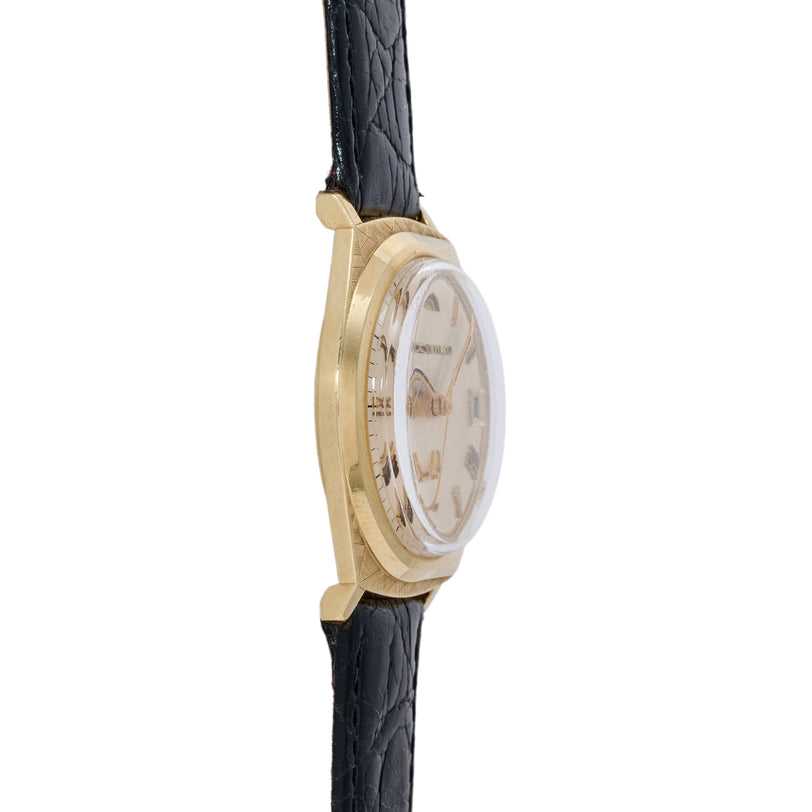 Gold-tone watch with cream dial, rectangular hour markers, and black quilted leather strap.