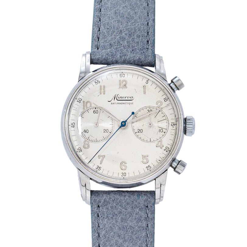 Minerva chronograph watch with silver case, cream dial, blue hands, two subdials, and gray fabric strap.