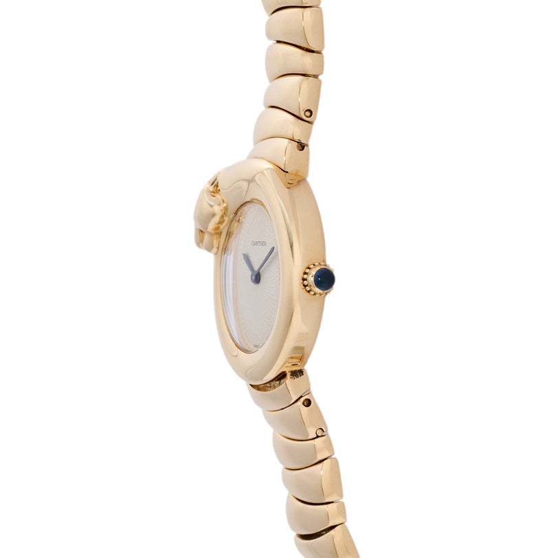Gold-tone watch with oval cream dial, blue hands, dark blue stone at 3 o'clock, and segmented bracelet with panther head deta