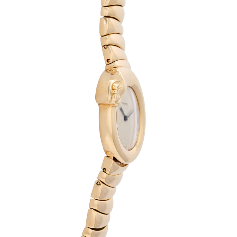 Gold-tone watch with oval dial featuring panther head detail and segmented bracelet band.
