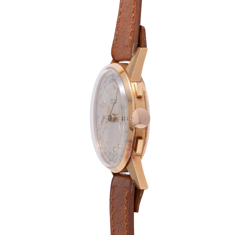 Gold-tone chronograph watch with cream dial and brown leather strap, shown from the side.