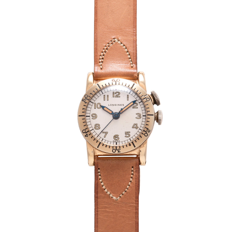 Longines Weems watch with cream dial, Arabic numerals, and tan leather strap with decorative stitching.