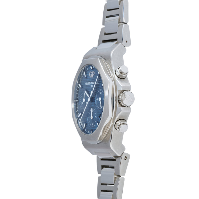 Stainless steel chronograph watch with blue dial, three pushers on right side, and matching metal bracelet with segmented lin