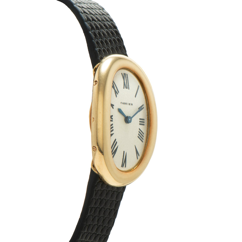 Gold-tone Cartier Baignoire watch with cream dial, Roman numerals, blue hands, and black leather crocodile-textured strap.