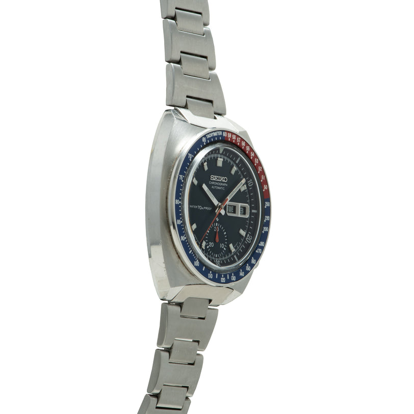 Seiko chronograph with black dial, blue and red bezel, date window, and stainless steel bracelet.