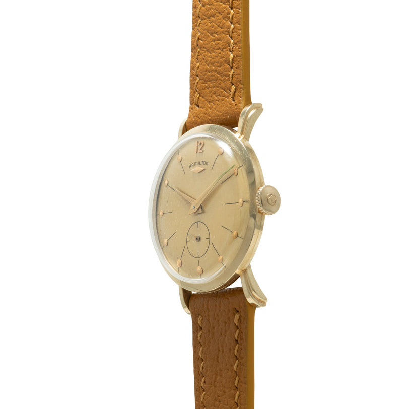 Hamilton watch with cream dial, applied indices, and side crown on tan leather strap.