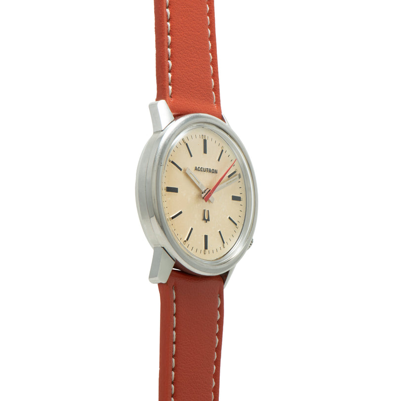 Bulova Accutron 218 dress watch with cream dial, black hour markers, red leather strap and stainless steel case.
