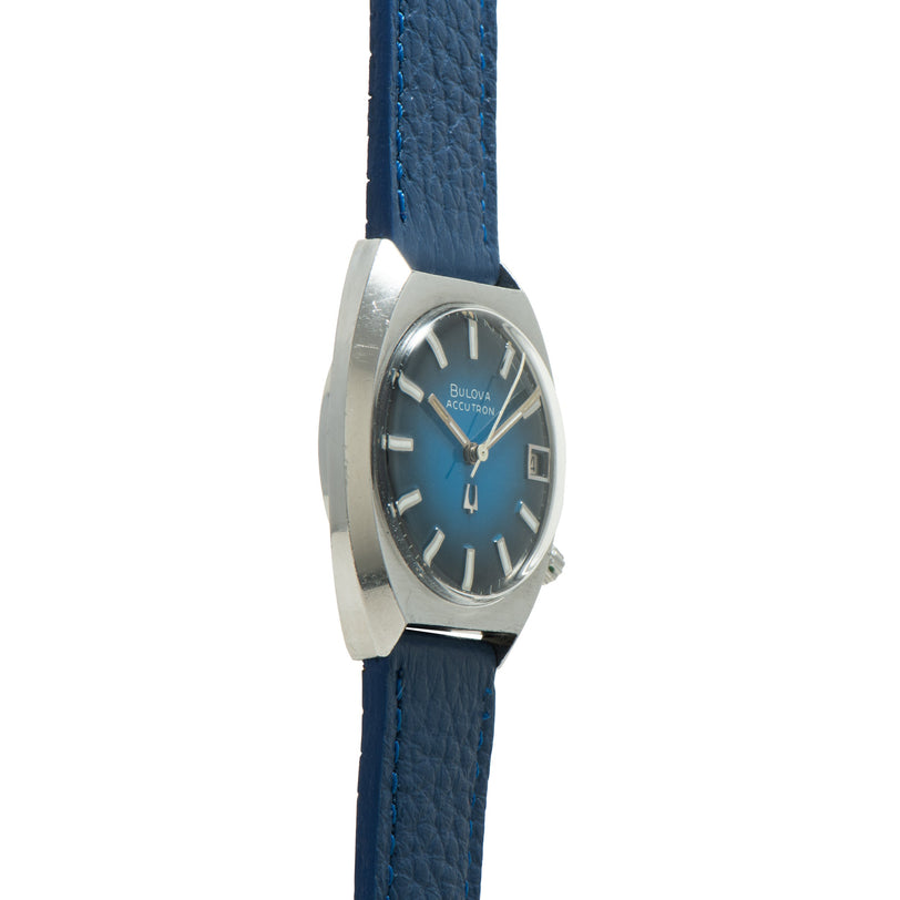 Bulova Accutron watch with blue gradient dial, silver-tone case, and blue leather strap.