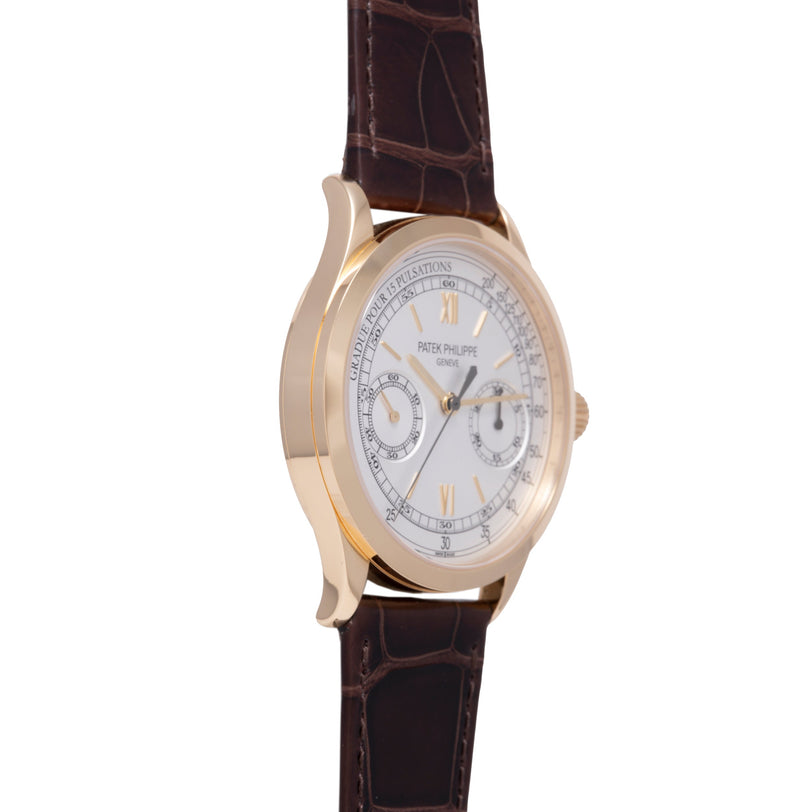 Gold-tone chronograph watch with white dial, Roman numerals, and dark brown leather strap.