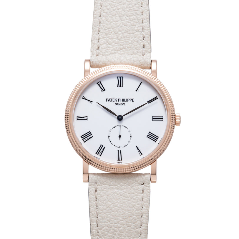 Rose gold watch with white dial, Roman numerals, subdial, and cream leather strap.