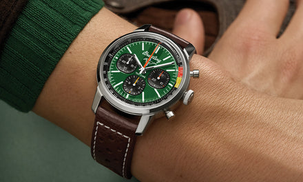 A Breitling Top Time watch with a green dial and three subdials on a wrist