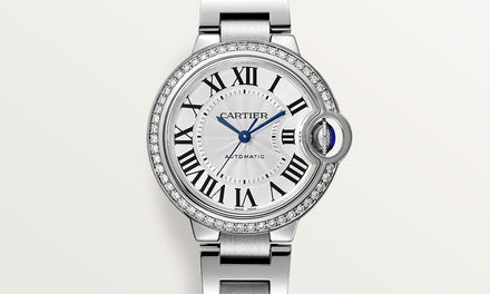 A close up view of the Ballon Bleu de Cartier watch showing a diamond bezel and black roman numeral markers