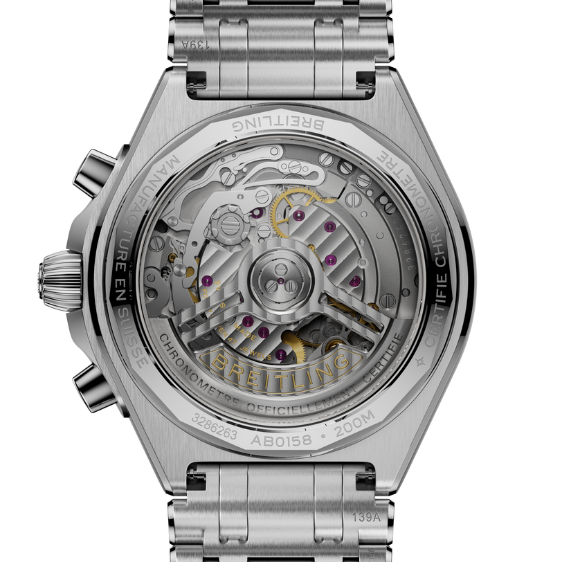 Stainless steel chronograph watch with visible mechanical movement through transparent caseback and three-link metal bracelet