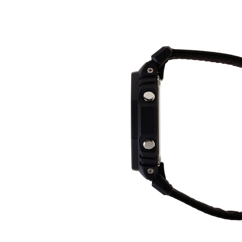 Black digital watch with resin case, metallic buttons, and textile strap shown from the side view.