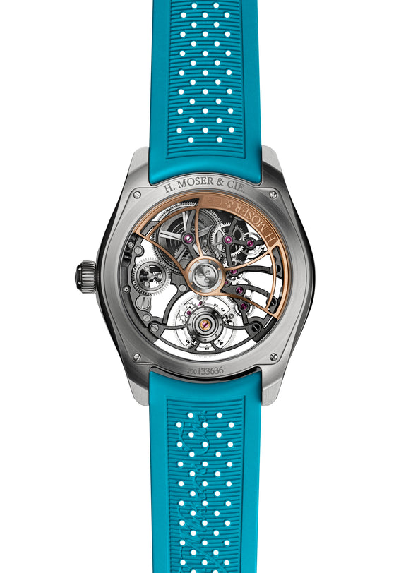 Back view of the H. Moser & Cie Pioneer Cylindrical Tourbillon Skeleton Spiced Aqua, showcasing visible gears and a vibrant blue perforated rubber strap.