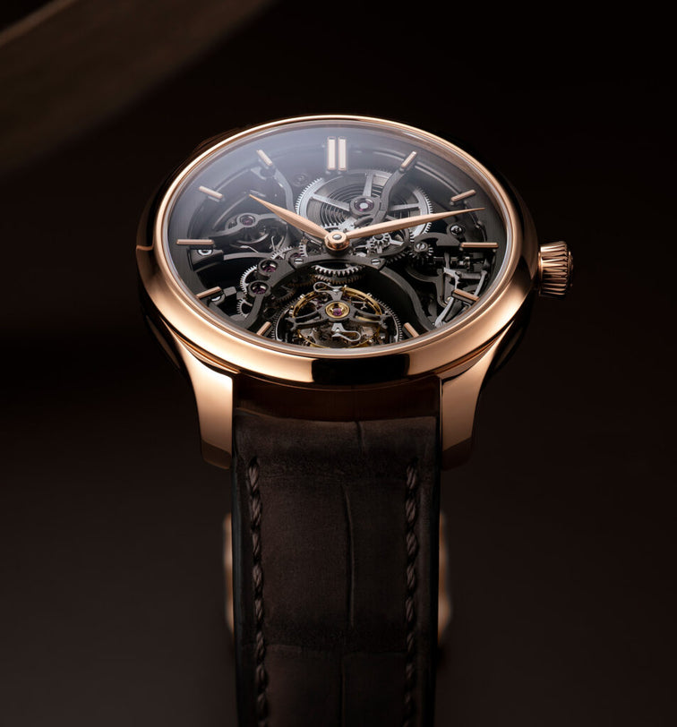Luxury watch with black leather strap and rose gold case on a dark background