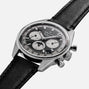 The Zenith Chronomaster Original Triple Calendar Limited Edition For Hodinkee features a modern chronograph design with a black leather strap, black and silver dial with three subdials, shown on a white background.