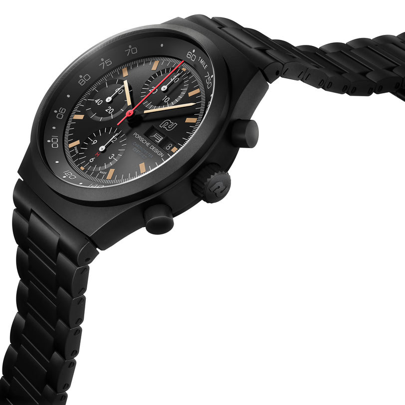 The Porsche Design Chronograph 1 Hodinkee 2024 Edition features a black metal band, black dial with multiple subdials, and a striking red second hand.