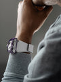 Close-up of a person wearing the MB&F HM8 Mark 2 Titanium Limited Edition Watch in white and purple, resting their hand on their chin.
