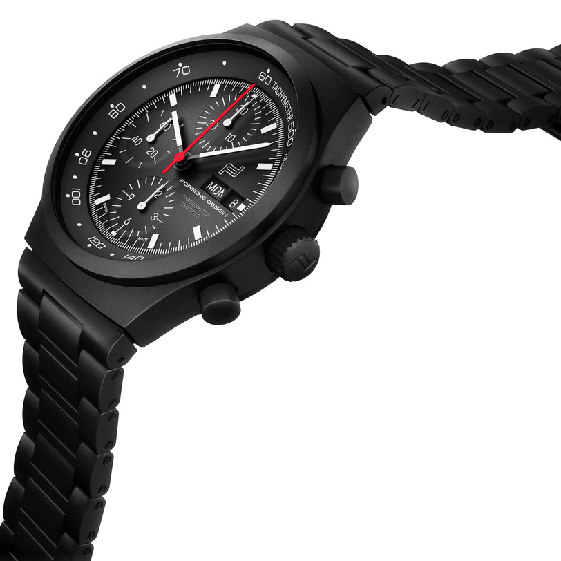 The Porsche Design Chronograph 1 All Black Numbered Edition features a matte black case, black metal bracelet, red second hand, and multiple subdials.