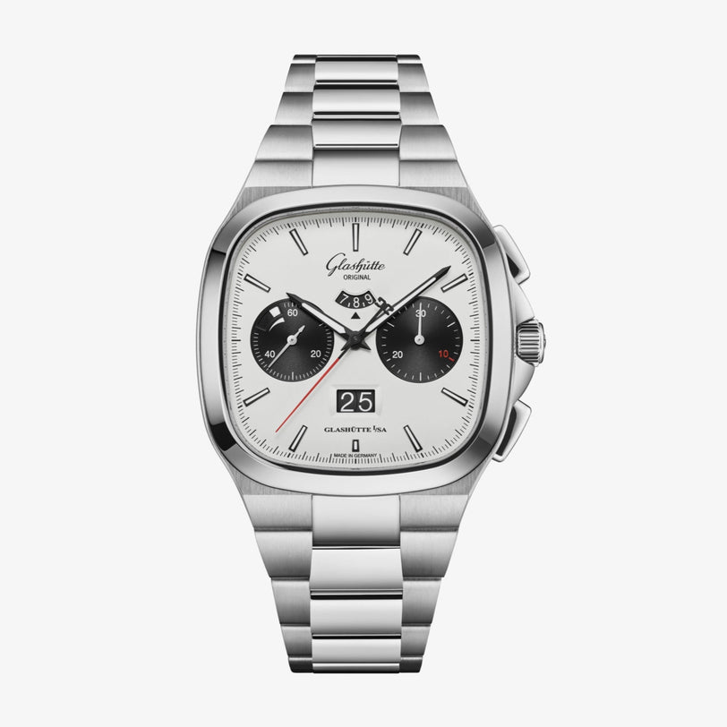 The Glashütte Original Seventies Chronograph Panorama Date features a silver metal bracelet, white dial, black subdials, and a prominent panorama date at 6 o’clock.