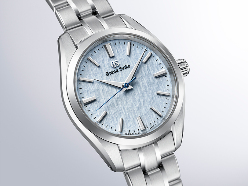 Silver watch with a light blue face on a light gray background