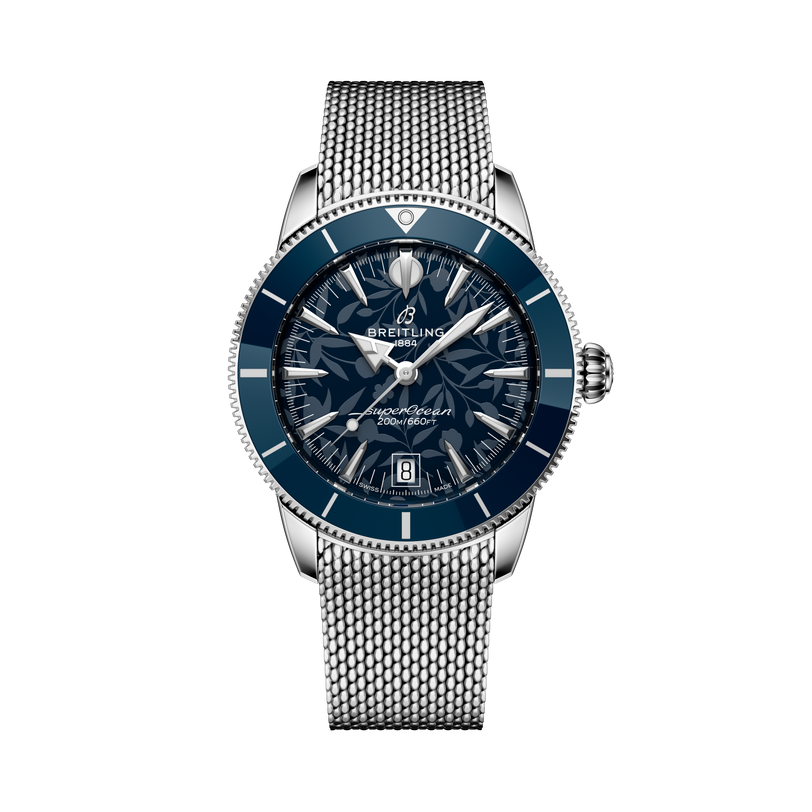 The Breitling Superocean Heritage B31 Automatic 40 Kelly Slater wristwatch features a blue patterned dial and mesh metal strap, showcased against a black background.