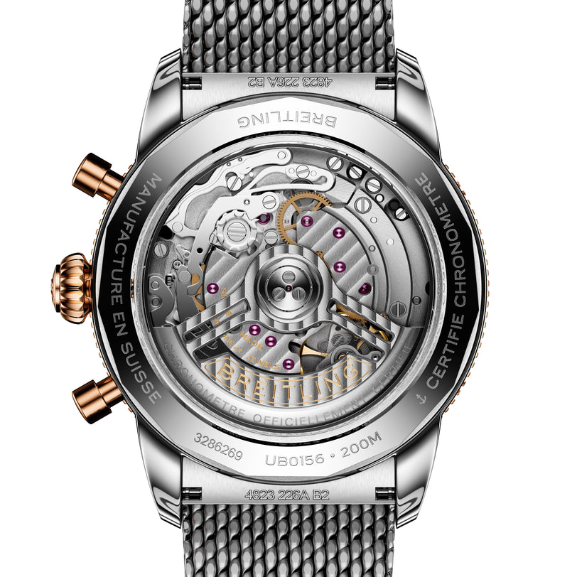 Close-up of the Breitling Superocean Heritage B01 Chronograph 42 watch back, revealing its detailed mechanical movement and metal mesh strap.