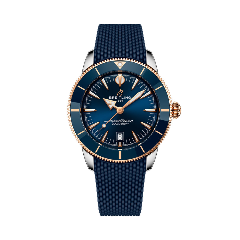 The Breitling Superocean Heritage B31 Automatic 44 features a blue and gold design, a blue strap, and a date display at 6 o’clock.