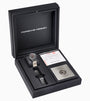 A Porsche Design Chronograph 1 50 Years 911 Turbo Edition watch in an open black box with a spare band, certificate, and metal plaque.