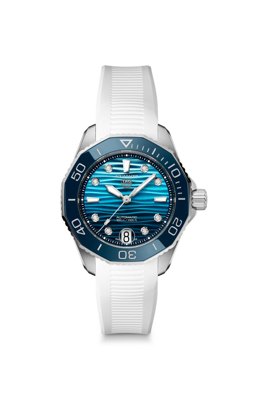 The TAG Heuer Aquaracer Professional 300 Date is a silver wristwatch with a blue face, diamond markers, and a white rubber strap.