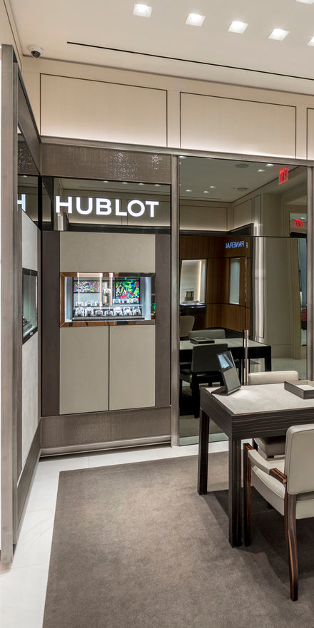 Luxury boutique interior with Hublot watch display, modern furniture, and elegant lighting.