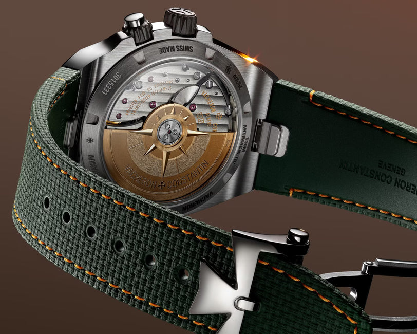 Chronograph watch with bronze dial featuring cardinal points, stainless steel case, and green fabric strap with orange stitch