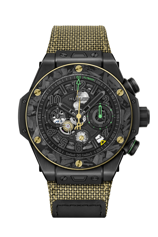 Black ceramic chronograph watch with gold-tone bezel, green accents, skeleton dial, and yellow-gold woven fabric strap.