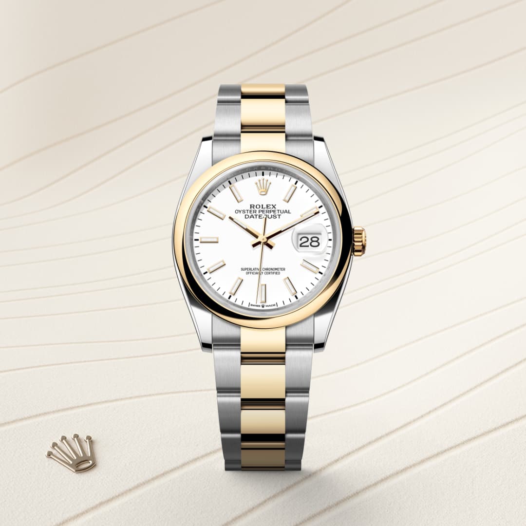 A two-tone Rolex Datejust watch with a white dial and gold accents displayed on a textured beige surface.