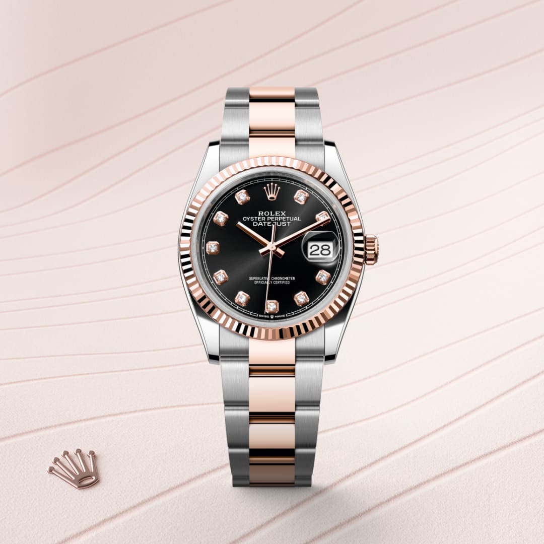 A two-tone Rolex watch with a black dial, date display, and diamond hour markers on a light patterned background.