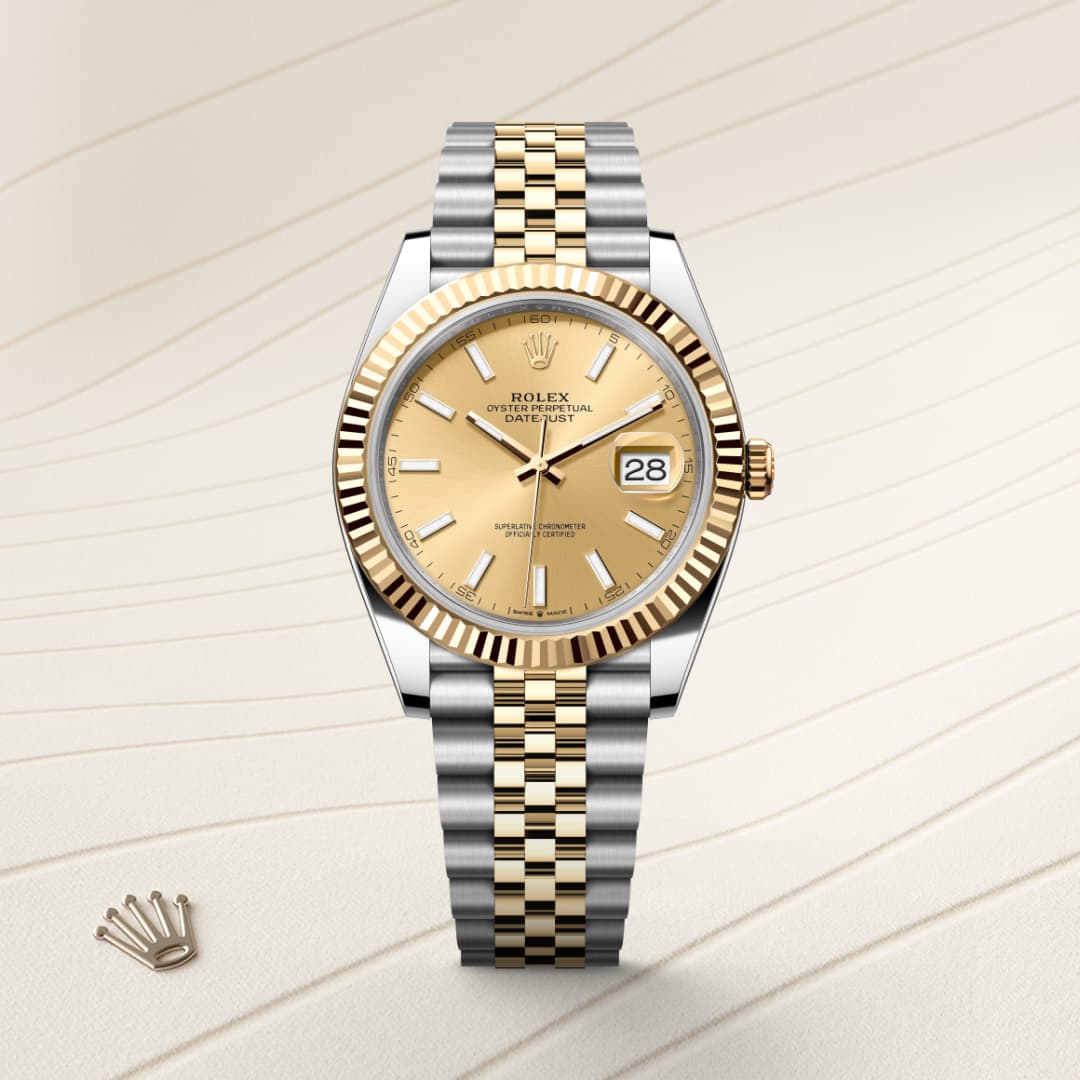 A gold and silver Rolex Datejust watch with a champagne dial and date display, on a light textured background.