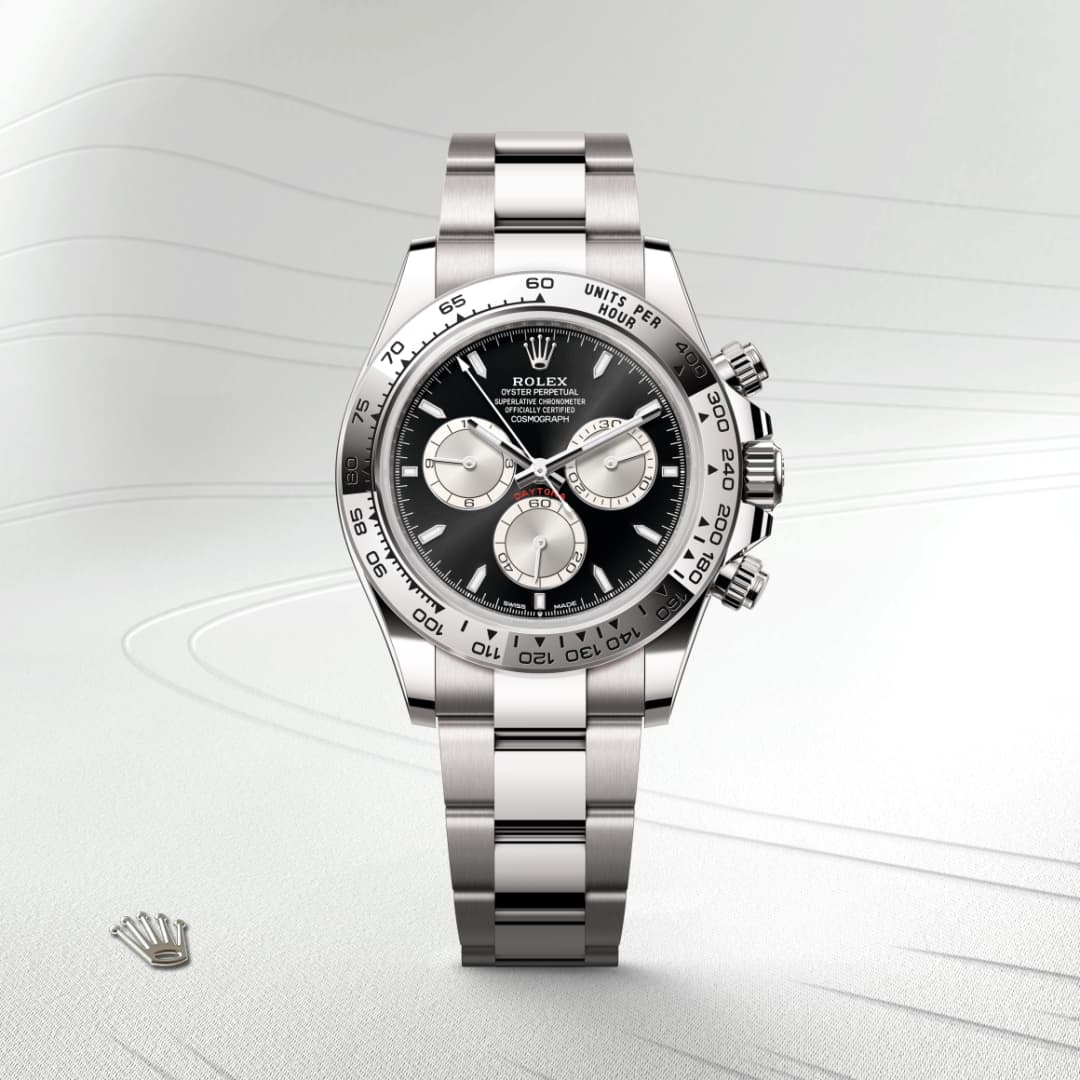 A Rolex Cosmograph Daytona watch with a silver bracelet and black dial displayed on a light textured background.