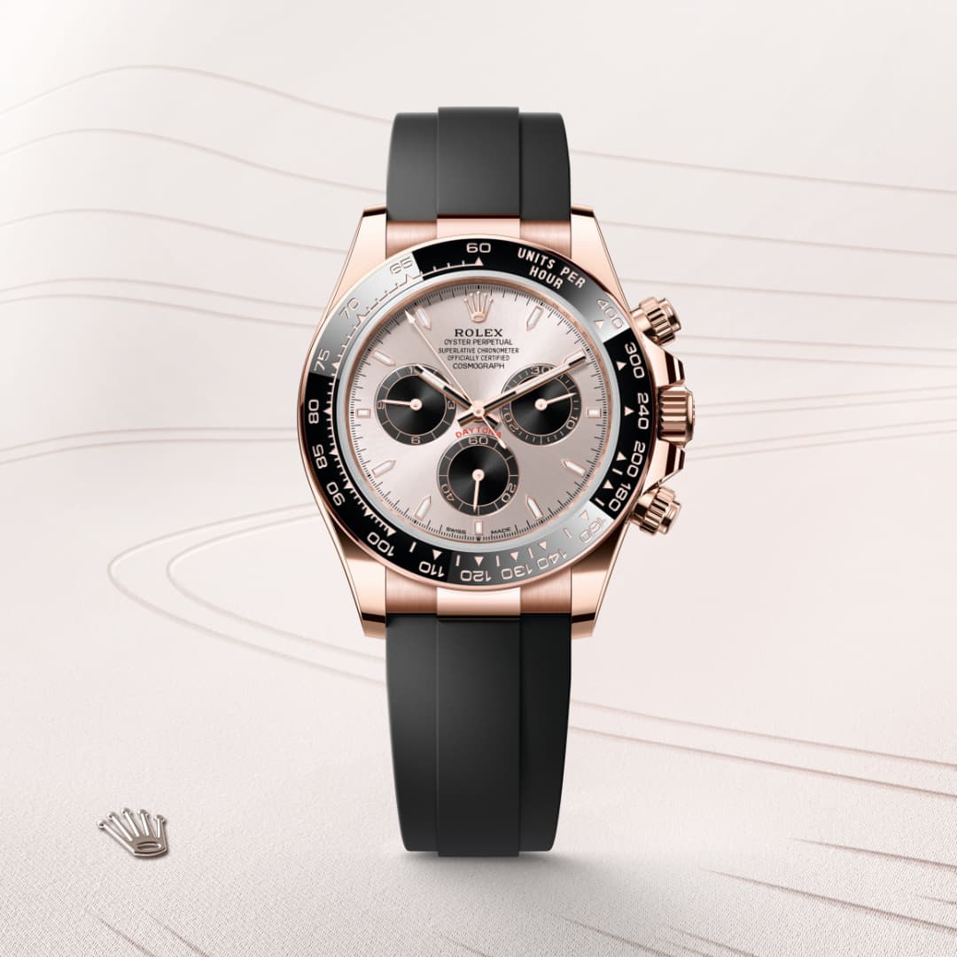 A rose gold Rolex watch with a black strap and three subdials displayed on a light, wavy background.