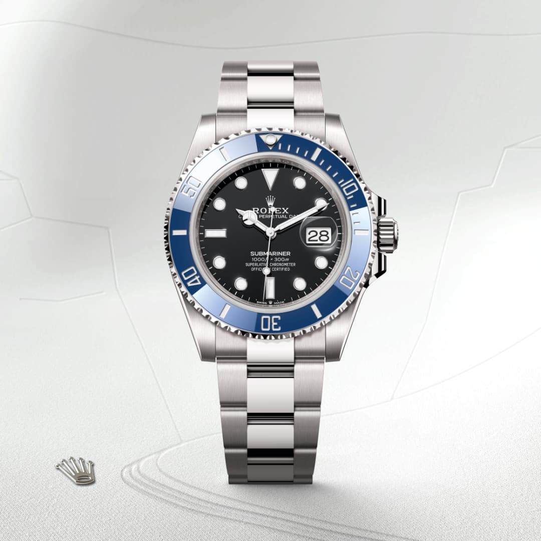 A silver Rolex Submariner watch with a black and blue bezel, displayed on a light textured background.