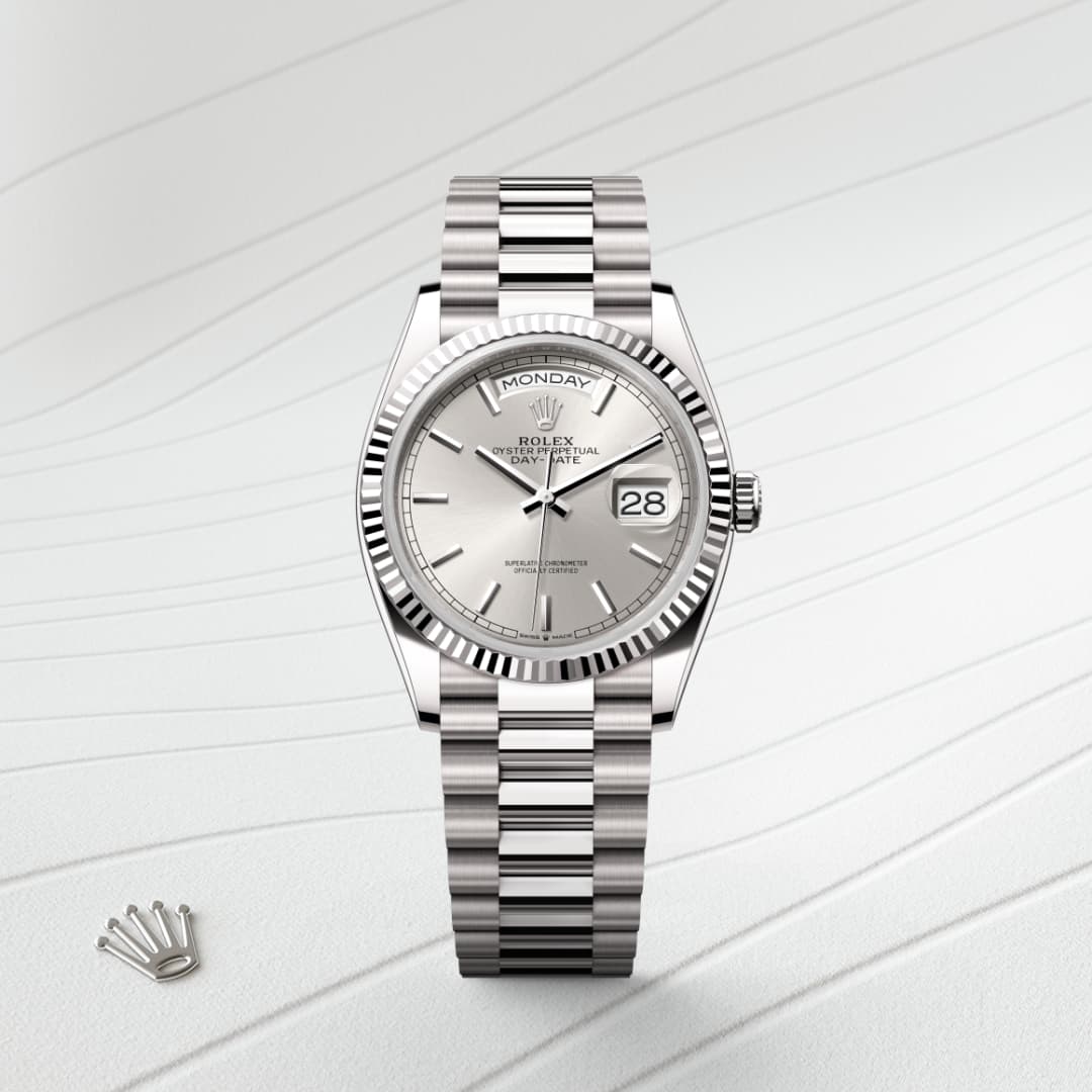 A silver Rolex wristwatch with a metal band displayed on a light textured surface.