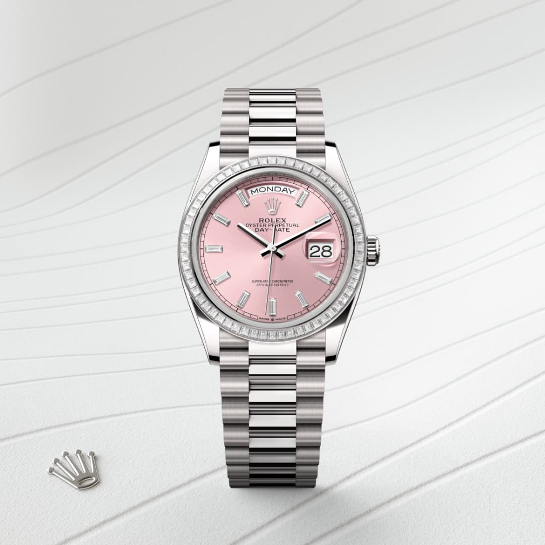 Silver Rolex watch with a pink dial and date display, placed on a light textured background.