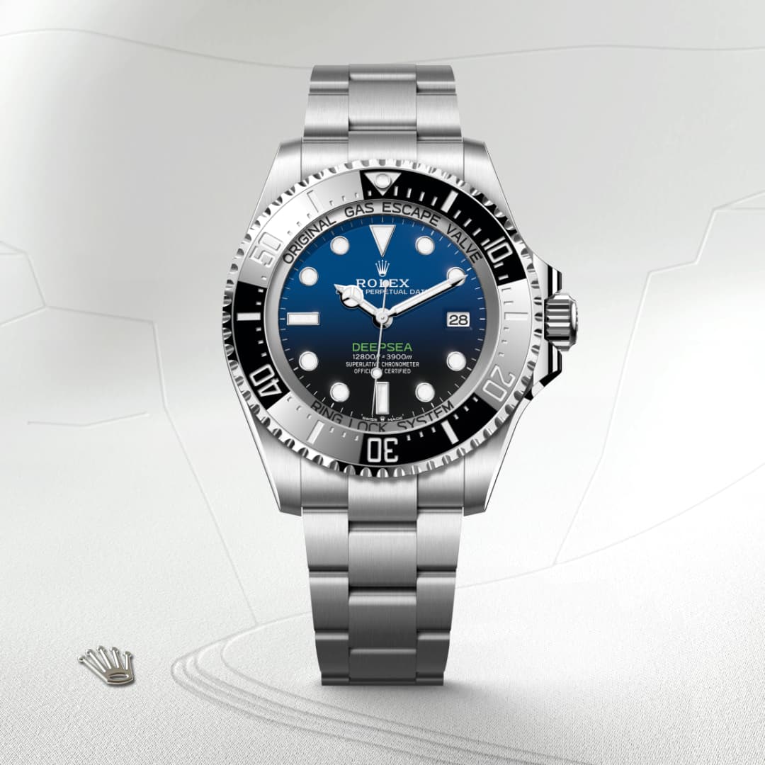A Rolex Deepsea stainless steel dive watch with a blue-black gradient dial and silver bracelet on a light surface.